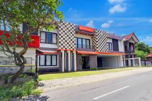 A boutique hotel with a checkered facade, a red awning, and a visible entrance. - Collection O Near Bali Royal Hospital Renon (Denpasar)