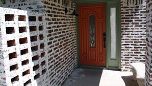 A brick wall with a door, a window, and a bench. - Cozy Court House near Flower Mound and Lewisville (Flower Mound)