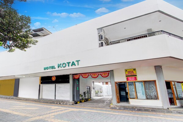 Un edificio con un cartel que dice 'HOTEL KOTAT' y un vestíbulo techado.