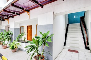 Un edificio con escaleras, plantas en macetas y una pared de azulejos azules.