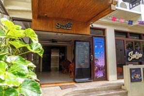 A restaurant named 'Serene' with a sign above the entrance, a refrigerator with a menu, and a dining area visible inside. - Serene La Playa (Malay)