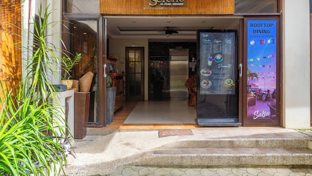 The entrance to a restaurant with a sign reading 'Serene La Playa Brisa' and a menu board advertising 'Rooftop Dining' from 12:00 PM to 10:00 PM. - Serene La Playa (Malay)