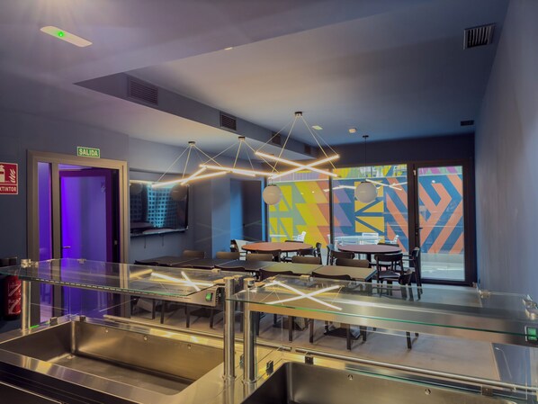 A modern restaurant with a glass partition, metal furniture, and geometric wall art. - La 15 Palmera Residence By Soho Boutique (Seville)