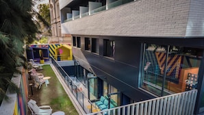 Um edifício moderno com telhado plano, janelas amplas e uma varanda com área de estar ao ar livre.