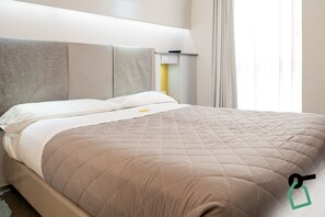 A hotel room with a bed, headboard, bedside table, and a window with curtains. - Hotiday Brindisi Vittoria (Brindisi)