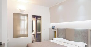 A hotel room with a bed, a mirror, a window, and a bathroom visible through an open door. - Hotiday Brindisi Vittoria  (Brindisi)