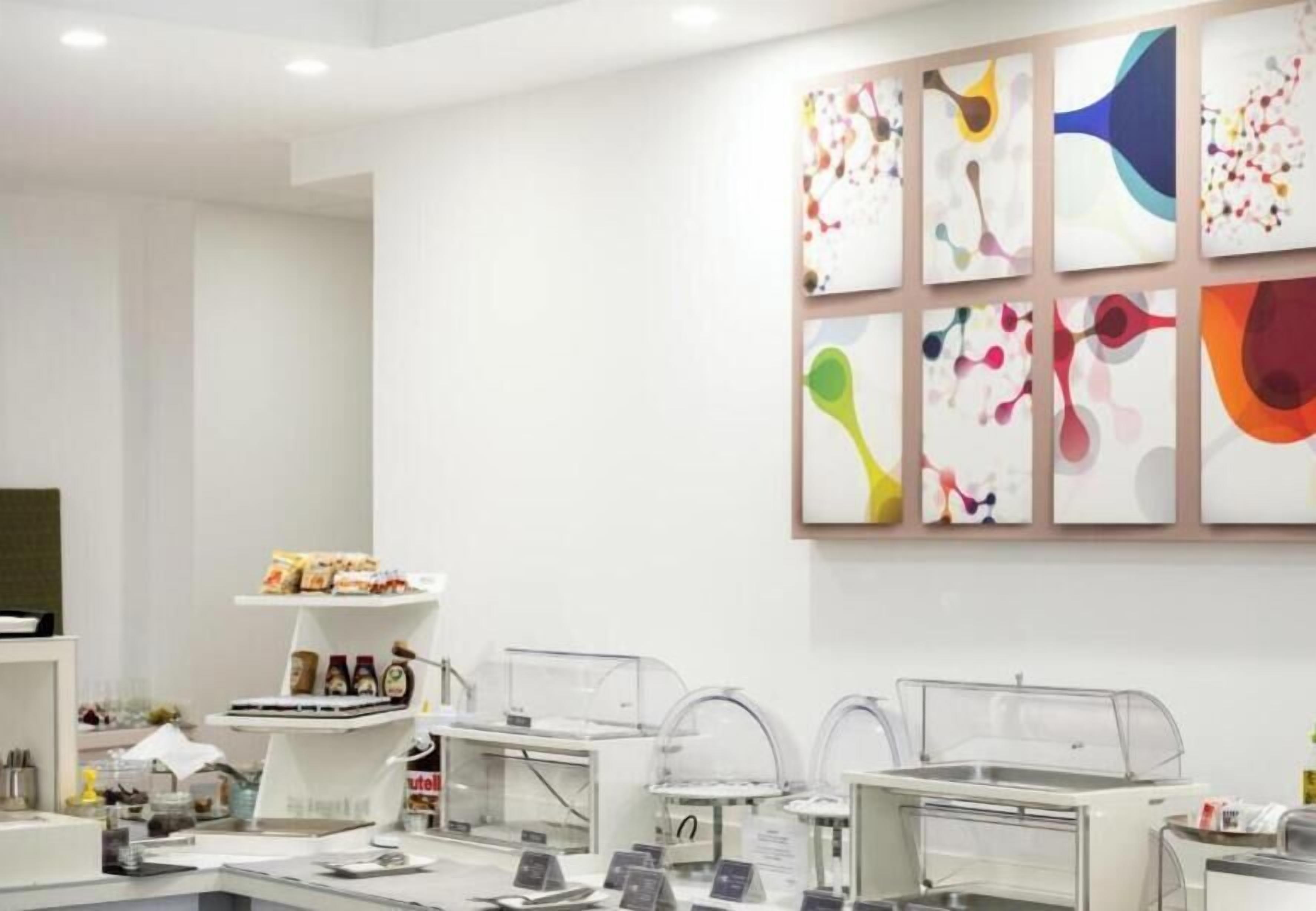 L'intérieur d'un cabinet dentaire moderne, avec un comptoir d'accueil, des fauteuils dentaires et une œuvre d'art accrochée au mur.
