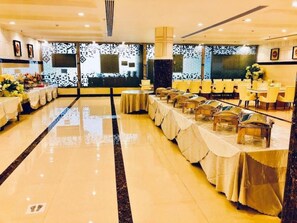 A banquet hall with tables set for a formal event, a large decorative wall, and a polished floor. - Riyadh Inn Hotel (Riyadh)