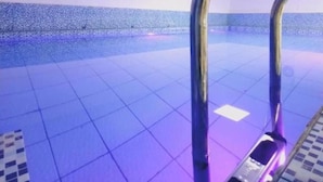 A swimming pool with tiled flooring and a metal pool ladder. - Riyadh Inn Hotel (Riyadh)
