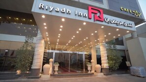 The exterior of Riyadh Inn with a prominent R logo, a covered entrance, and a glass facade. - Riyadh Inn Hotel (Riyadh)