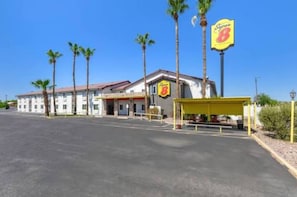 A motel with a yellow awning, palm trees, and a clear blue sky. - Super 8 by Wyndham Phoenix I-17 (Phoenix)