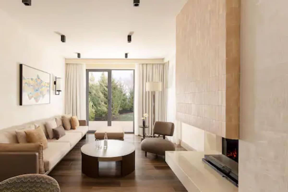 A modern living room with a sofa set, a coffee table, and a fireplace.