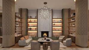 A modern living room with a fireplace, bookshelves, a sofa, and a coffee table. - Beldersoy Resort And Spa (Tashkent)