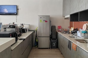 A modern kitchen with a refrigerator, microwave, and coffee maker. - C YOU Rooms (Semporna)