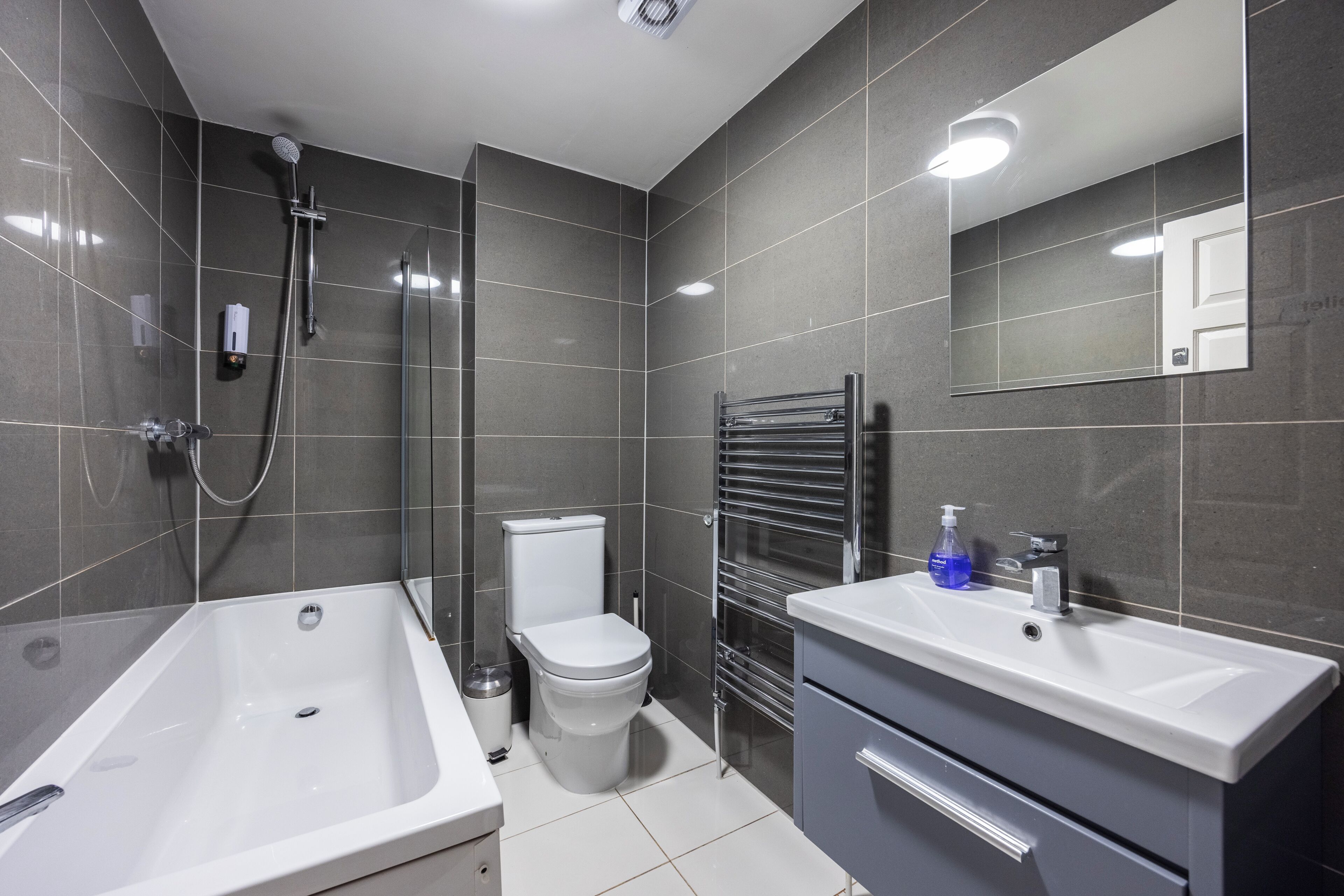 A modern bathroom with a bathtub, toilet, and sink.