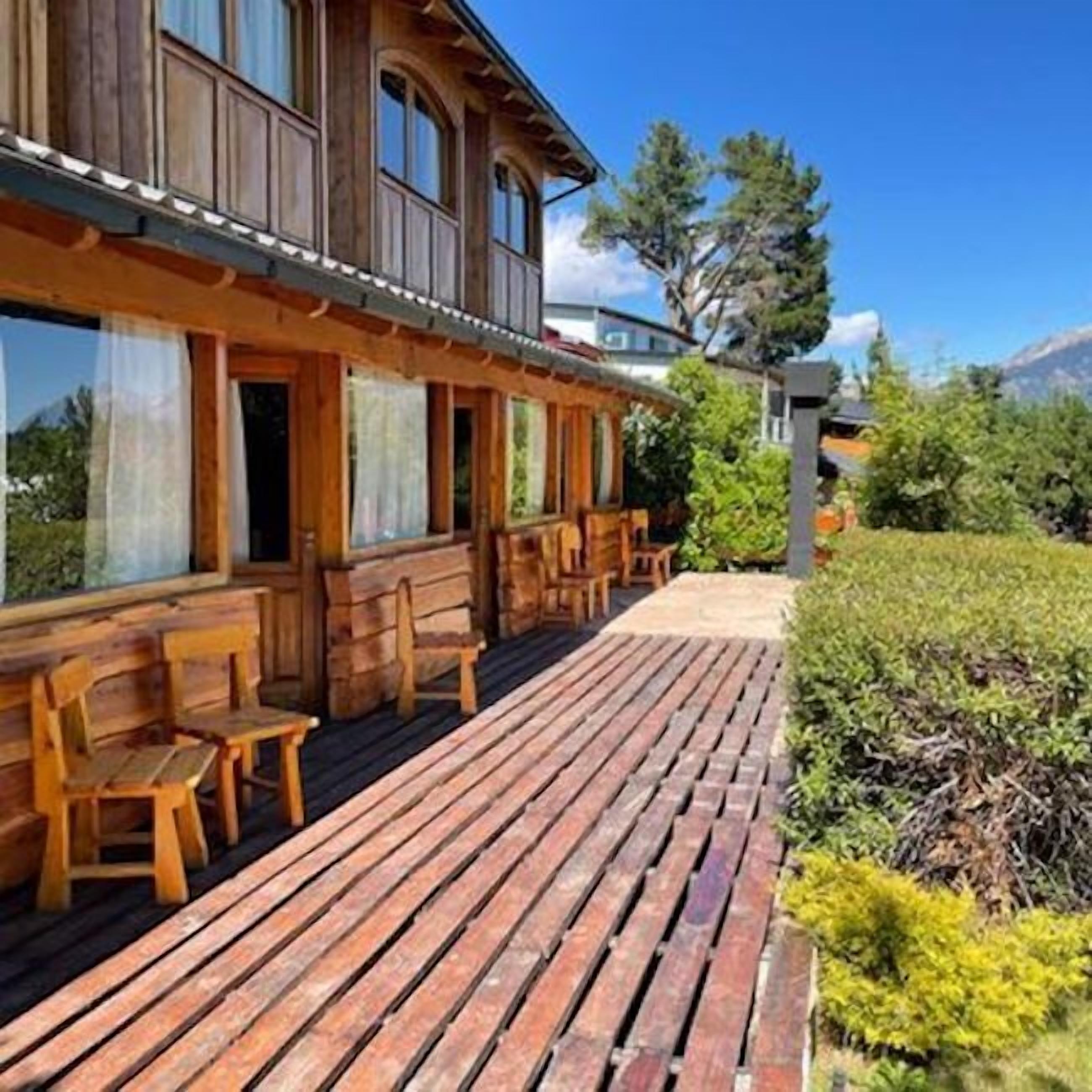Een houten gebouw met een overdekt terras en een houten vlonder.