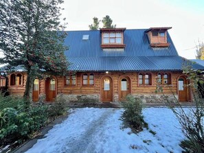Puinen talo, jossa on kivinen pohjarakenne, kalteva katto ja pieni ikkuna yläkerrassa.