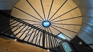 Una escalera de caracol con detalles de madera y un candelabro en el centro.
