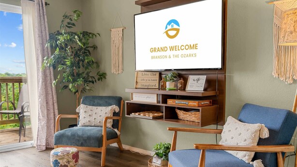 Een woonkamer met twee houten stoelen, een televisie en een plant.