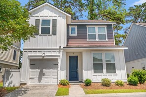 A two-story house with a garage, a front door, and a small porch. - The Cloisters at Myrtlewood  4 Bedroom Golf & Family Retreat, (Myrtle Beach)