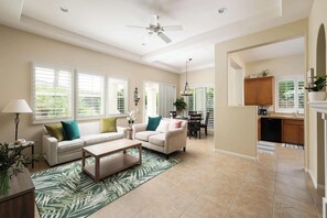 A spacious living room with a sofa, coffee table, and a dining area with a table and chairs. - Casa Veranda | Puerta Azul Pool Retreat (La Quinta)