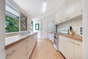 A modern kitchen with wooden cabinets, a stainless steel sink, and a built-in oven.