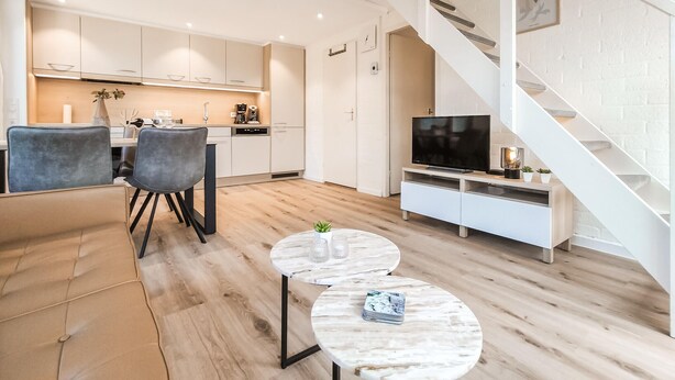 Eine moderne Wohnung mit Küche, Essbereich und Wohnzimmer.