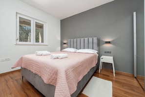 A bedroom with a bed, bedside tables, a window, and a wall-mounted light fixture. - Olive House Pool & Garden, Zemunik Donji, Croatia (Zemunik Donji)