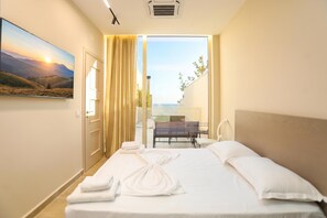 Habitación de hotel con una cama, vista a un balcón y un cuadro en la pared.