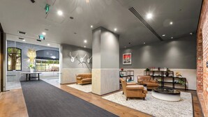 Eine moderne Lobby mit Ledersofas, einem Couchtisch und einem Kamin.