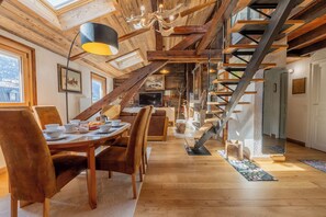A wooden interior with a dining area, staircase, and artwork. - Cristal in the heart of Chamonix Mountain view for 6, Chamonix, France (Chamonix)