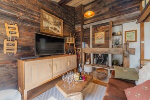 A rustic wooden interior with a television, wooden cabinet, and a cozy seating area. - Cristal in the heart of Chamonix Mountain view for 6, Chamonix, France (Chamonix)