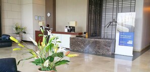 En reception med en marmor disk, et ur, indrammede certifikater og et skilt med 30% rabat.