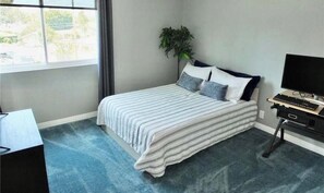 A bedroom with a bed, a desk, a computer, and a window. - Gorgeous 2-bedroom condo with AC in Long Beach two garages (Long Beach)
