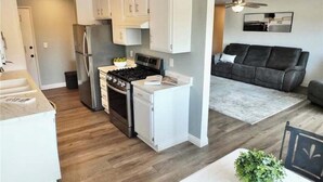 A modern kitchen with white cabinets, a stainless steel refrigerator, and a gas stove. - Gorgeous 2-bedroom condo with AC in Long Beach two garages (Long Beach)