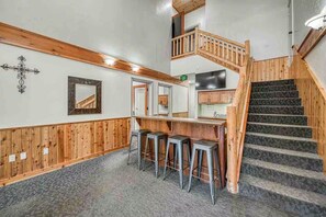 A staircase with wooden railings and a carpeted floor leading to a second level.