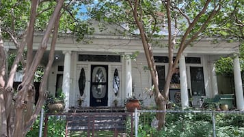 Un edificio bianco con una porta nera, colonne e un portico coperto.