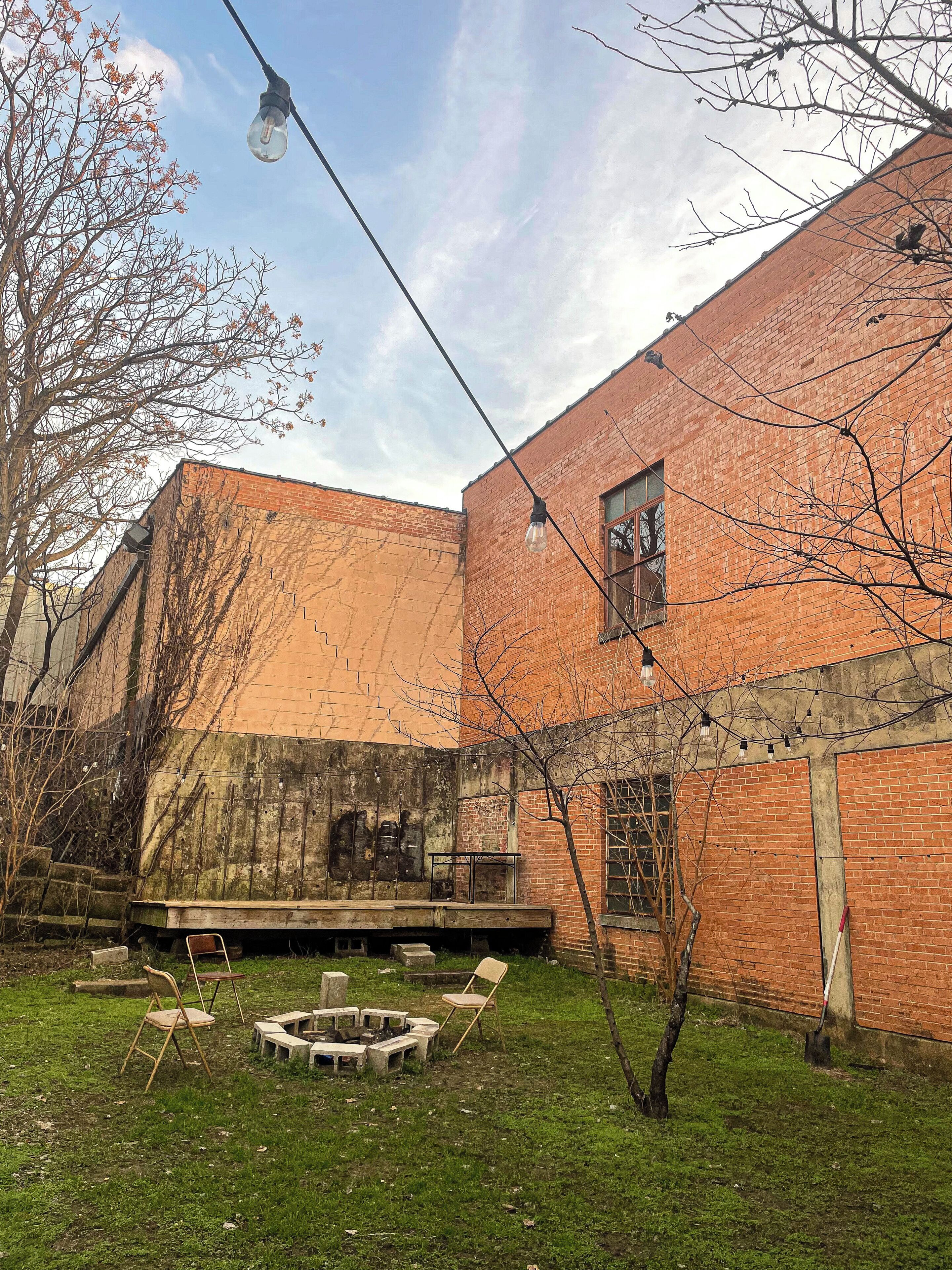 Un edificio in mattoni con cortile interno, posti a sedere all'aperto e un braciere.