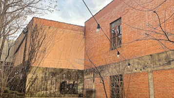 Un edificio in mattoni con cortile interno, posti a sedere all'aperto e un braciere.