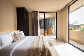 A modern bedroom with a large bed, a view to the outside, and a sliding glass door. - SISI Wellness Villas (Pecatu)