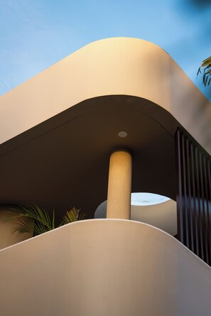 A modern building with a curved facade, a central pillar, and a skylight. - SISI Wellness Villas (Pecatu)