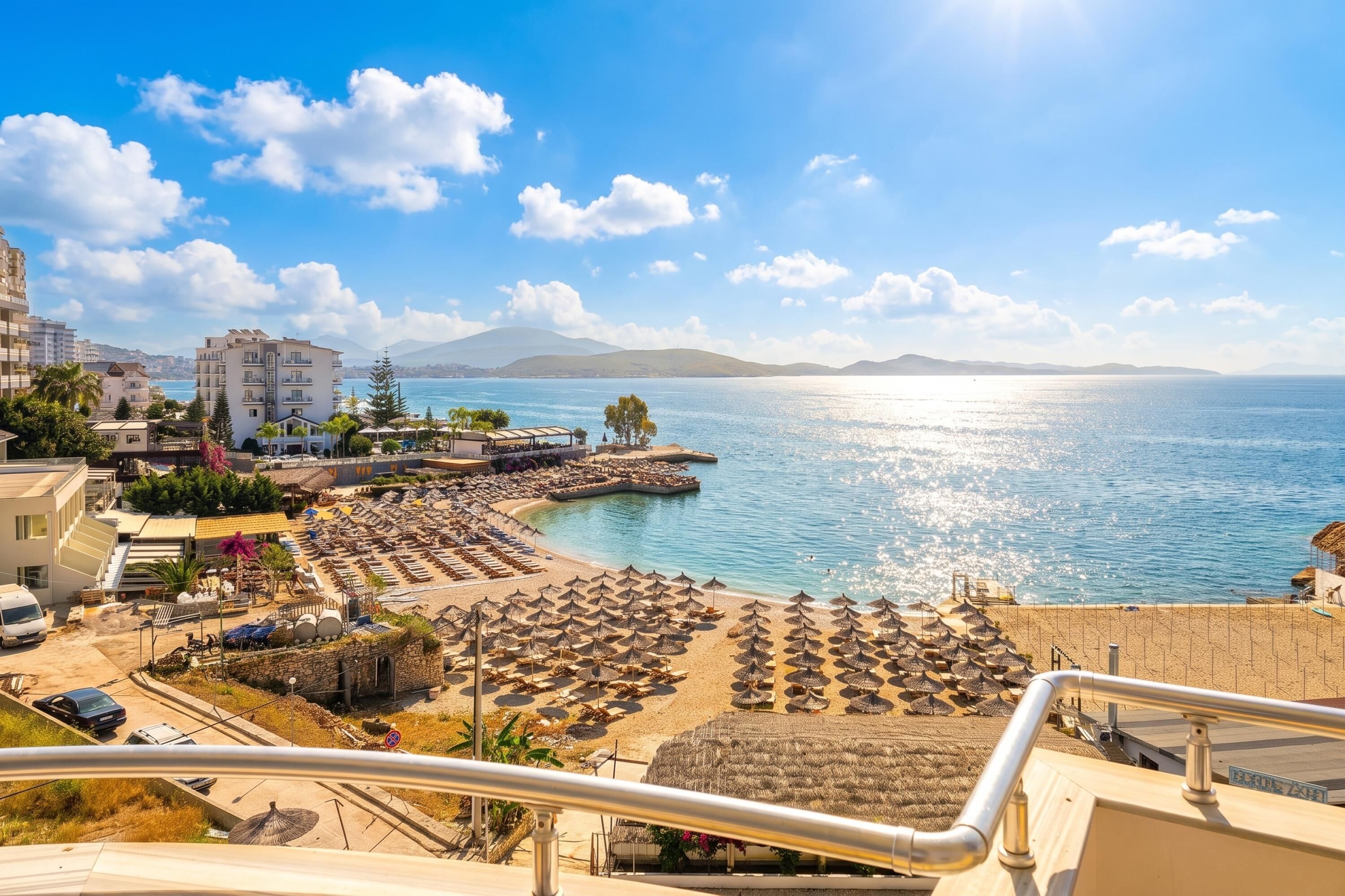 A coastal hotel with a beach, a pool, and a view of the sea.