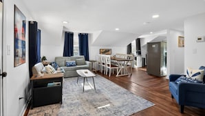 Uma sala de estar moderna com sofá, mesa de centro e área de jantar.