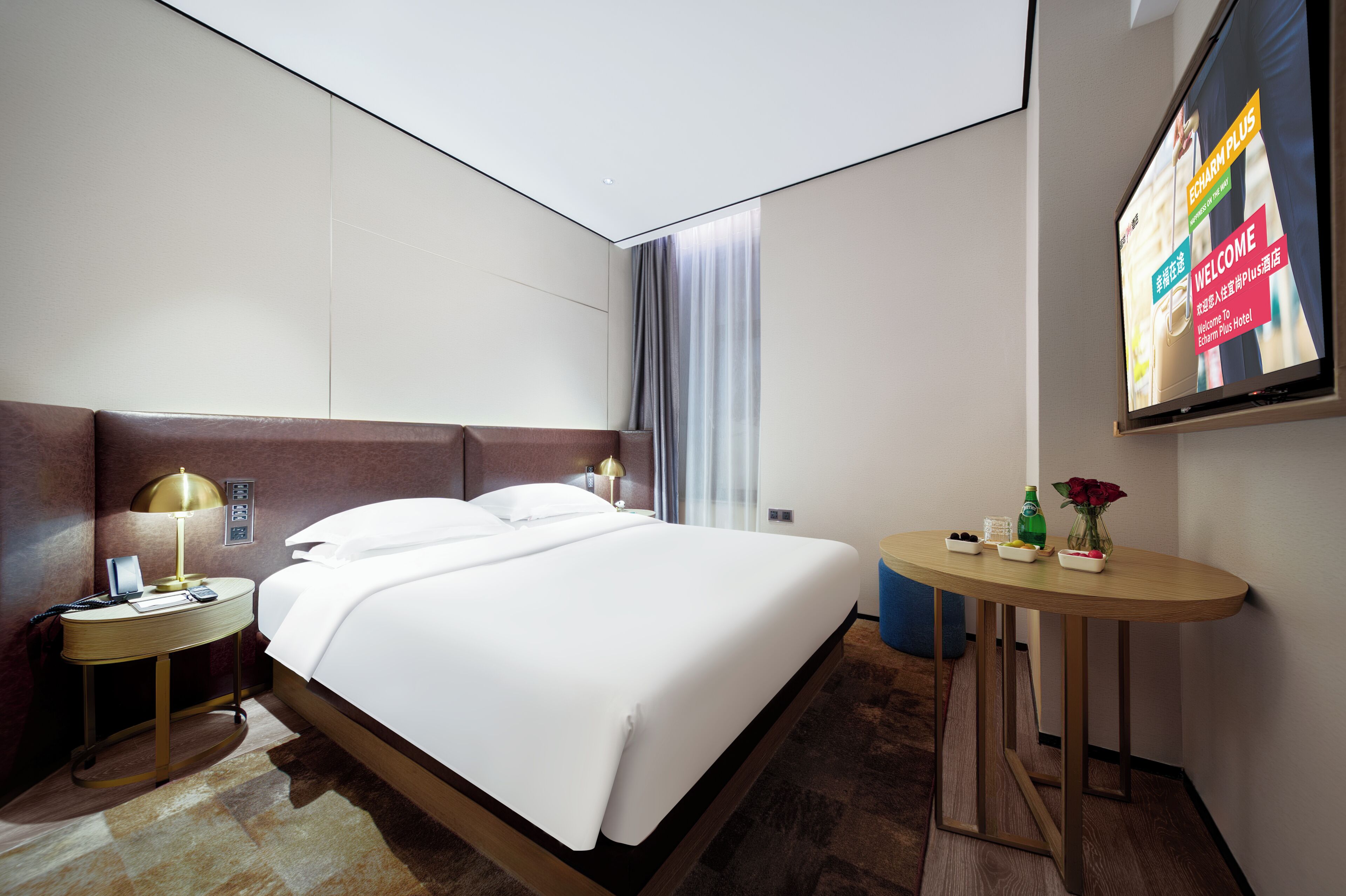 A hotel room with a bed, bedside tables, a desk, a TV, and a window with curtains.