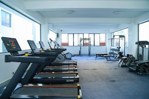 A gym with treadmills, weight machines, and dumbbells. - Cozy 2bed Master-ensuite apt in Nairobi Near the Airport and SGR Train Station (Syokimau)