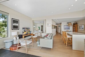 Ein modernes Hotelzimmer mit Wohnbereich, Essbereich und Blick ins Freie.