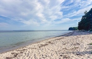 A beach with clear water, sandy shore, and a distant tree line. - 3 bedroom beautiful home in Faxe Ladeplads (Faxe Ladeplads)