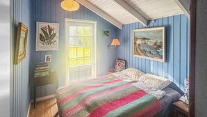 A bedroom with a bed, a window with blinds, a lamp, and wall art. - 3 bedroom beautiful home in Faxe Ladeplads (Faxe Ladeplads)
