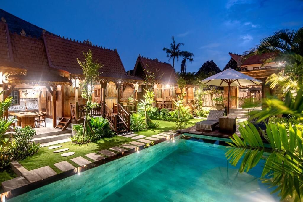 A poolside area with a swimming pool, wooden deck, and outdoor seating.