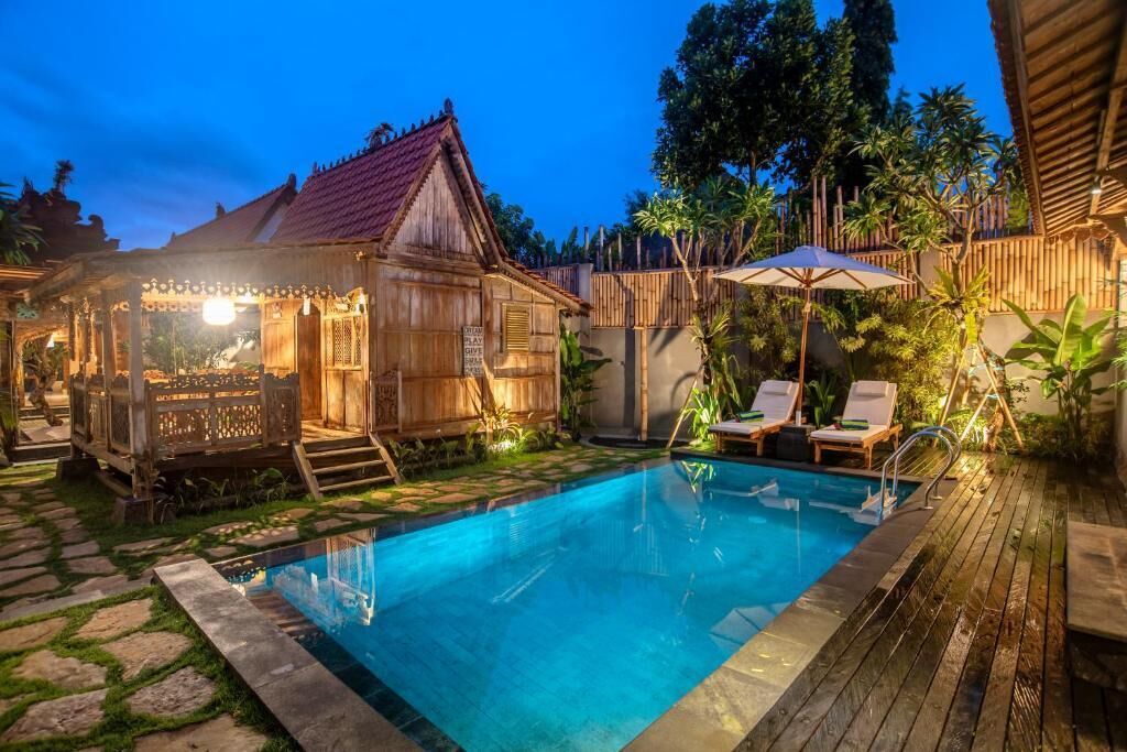 A wooden pool area with lounge chairs and a small wooden structure.